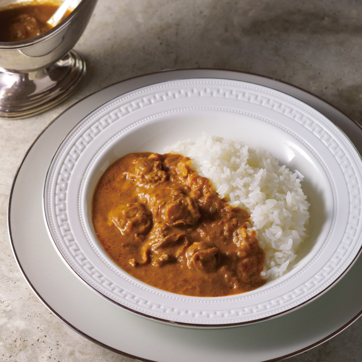 Plate of rice with scallop butter curry sauce in a shallow dish