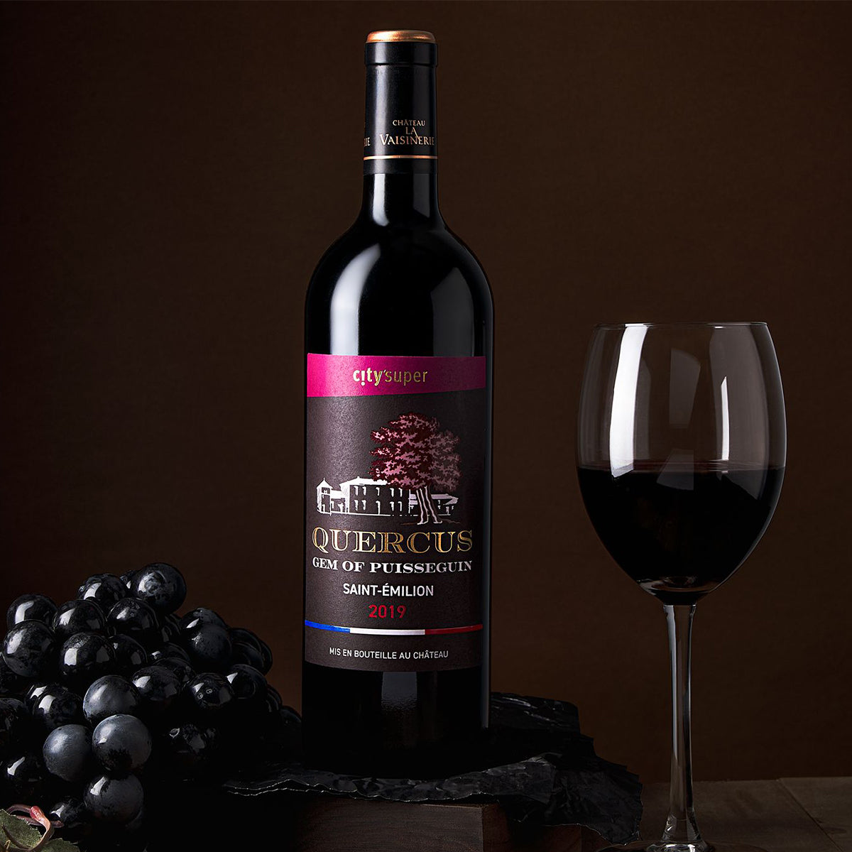 2019 Saint-Emilion red wine bottle with stemmed glass and dark grapes