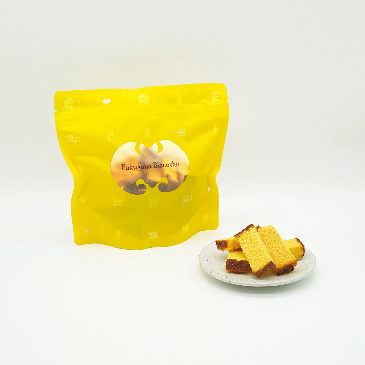 FUKUSAYA Bizcocho 100g yellow pouch with small cake cubes on white plate