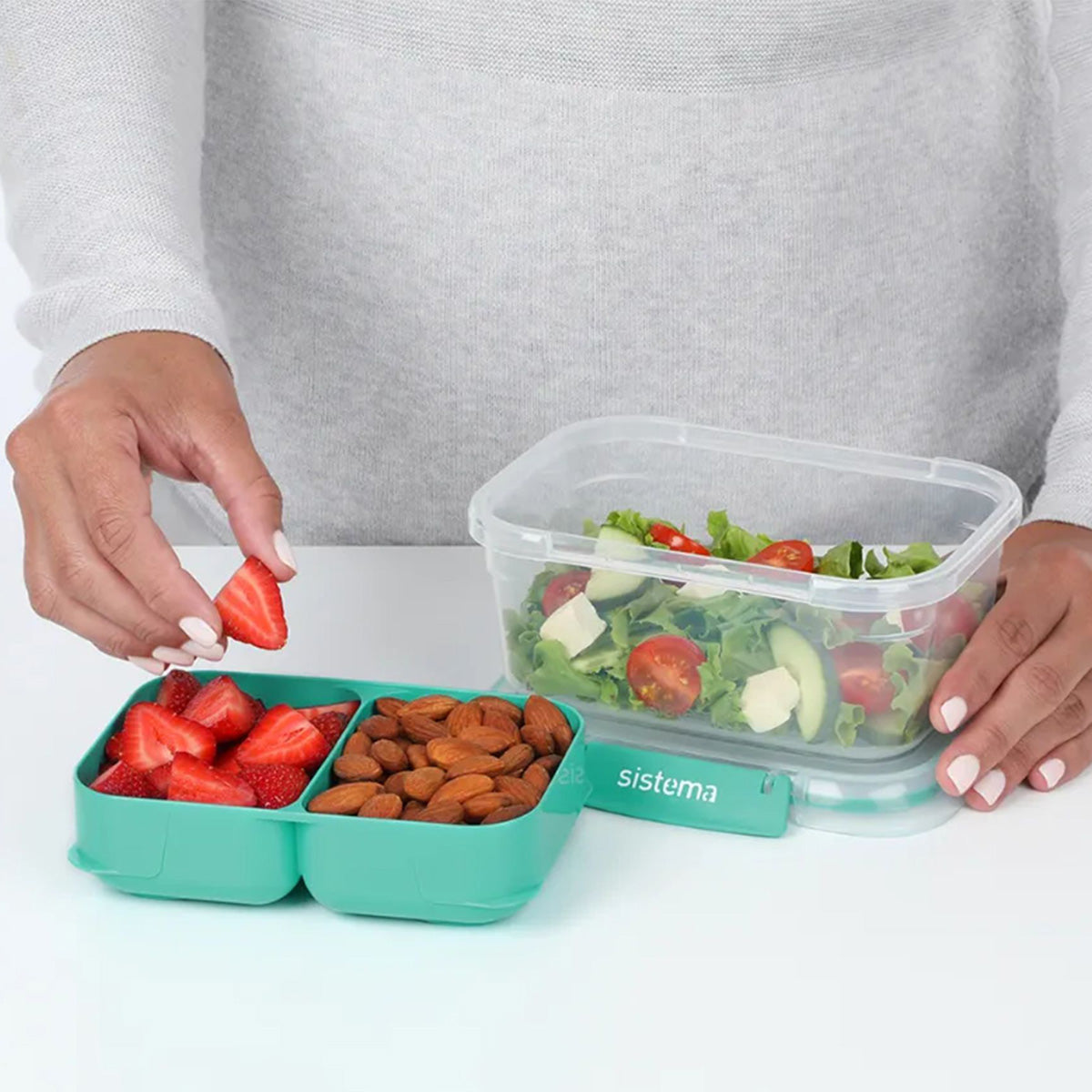 Stax To Go 1L container with teal compartments holding chopped vegetables and meat