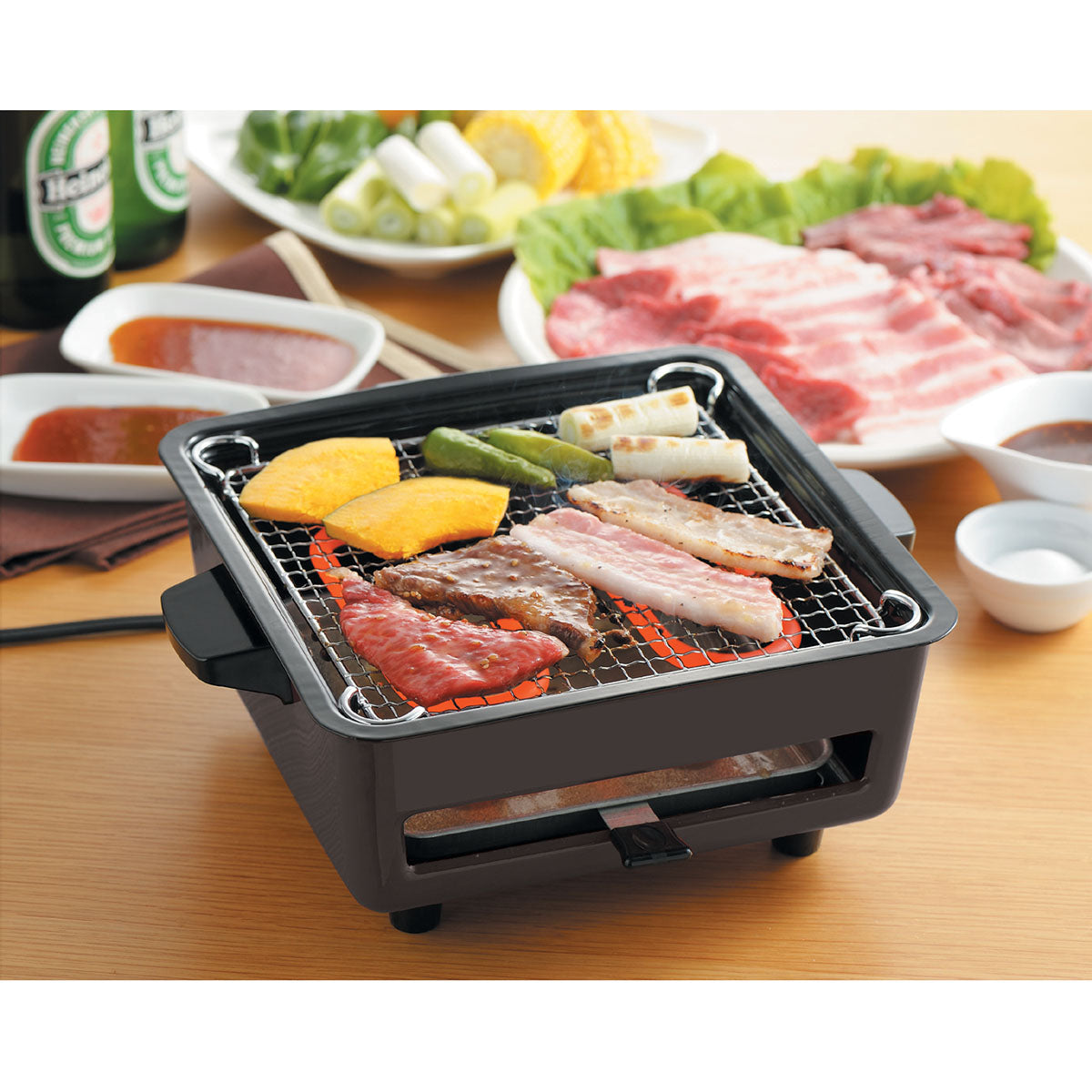 Electric indoor grill with wire grate cooking bacon, vegetables, and corn slices