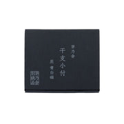 Black gift box with vertical white lettering on front panel