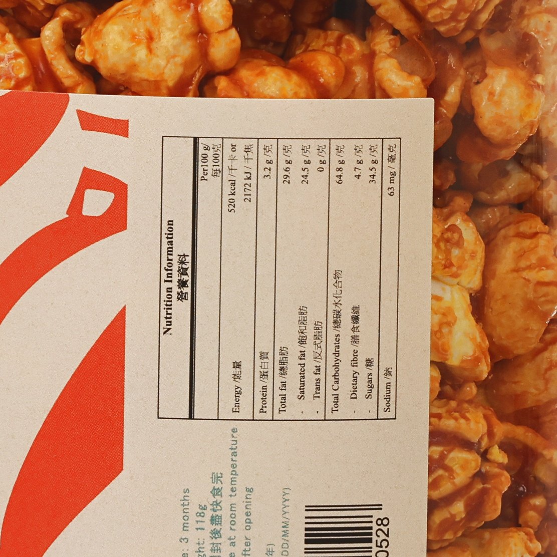 Nutrition information label on caramel popcorn packaging with popcorn kernels beside