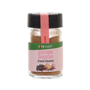 Ground cinnamon seasoning jar with black cap and brown powder in clear glass