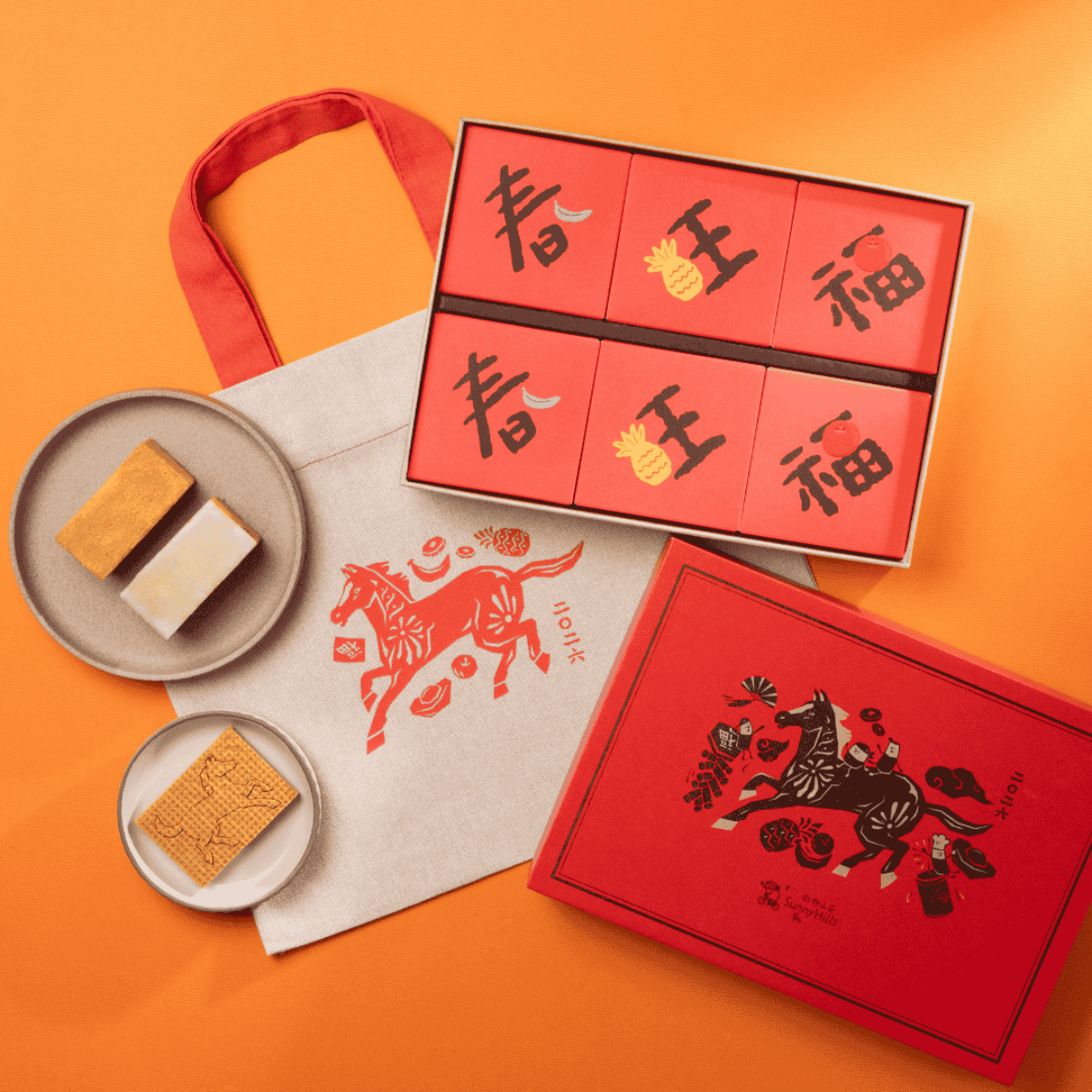 Gift box set with red boxes, ribbon, and square cookies on plates