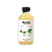 Calamansi green tea kombucha bottle with black cap and front label with cartoon characters