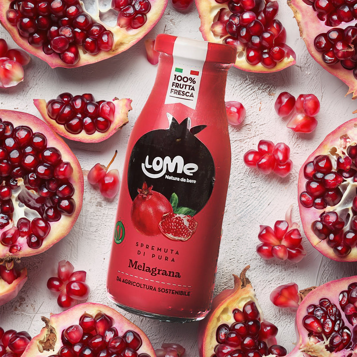 200 mL pomegranate juice bottle with pomegranate fruit around it