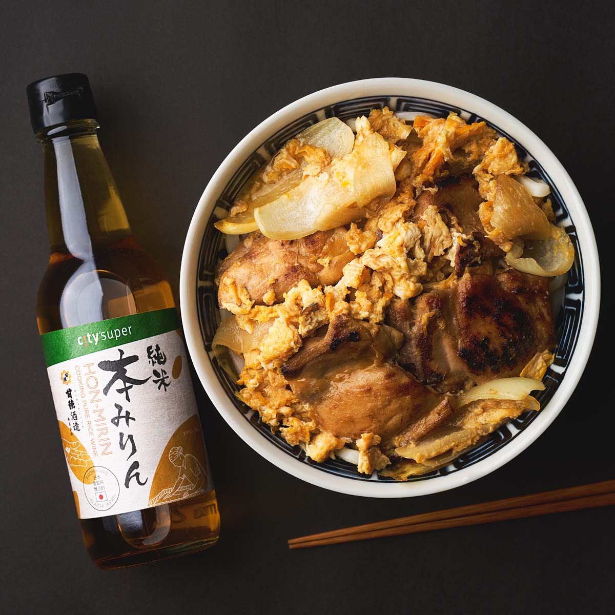 CITYSUPER hon-mirin rice wine bottle with bowl of cooked food beside it.