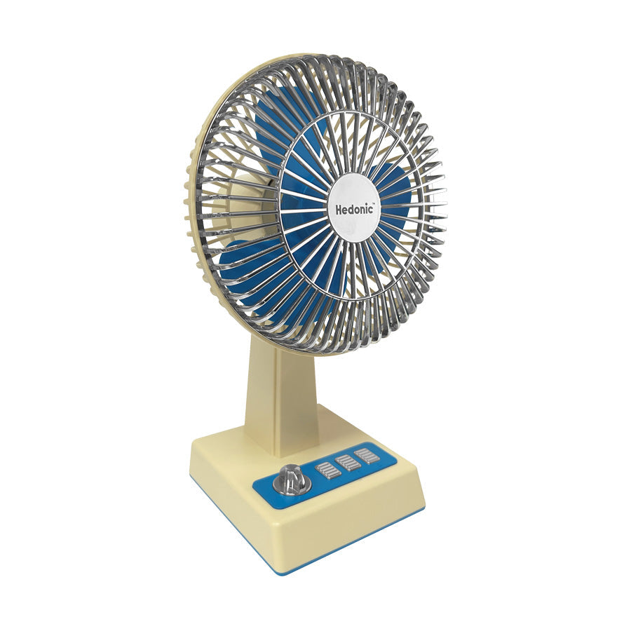 Vintage desk fan with blue metal grille and blades, cream base, HEDONIC logo