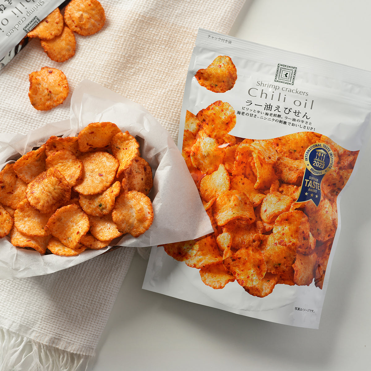 KINOKUNIYA chili oil shrimp crackers pouch with open bag of orange chili crackers