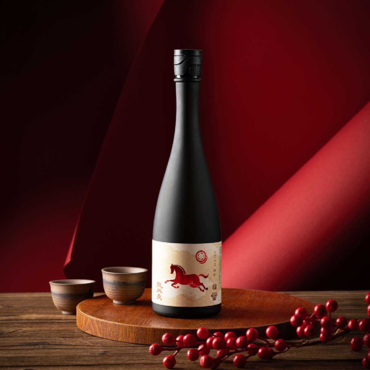 Dark sake bottle with black cap and cream label featuring a red zodiac horse