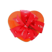 Heart-shaped cookie tin with red ribbon bow on orange lid