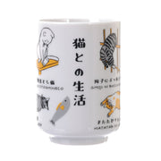 White ceramic tea cup with assorted cat illustrations and Japanese text