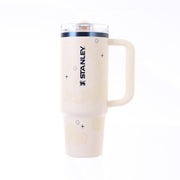 Cream STANLEY tumbler with flip straw lid, clear top, and side emblem