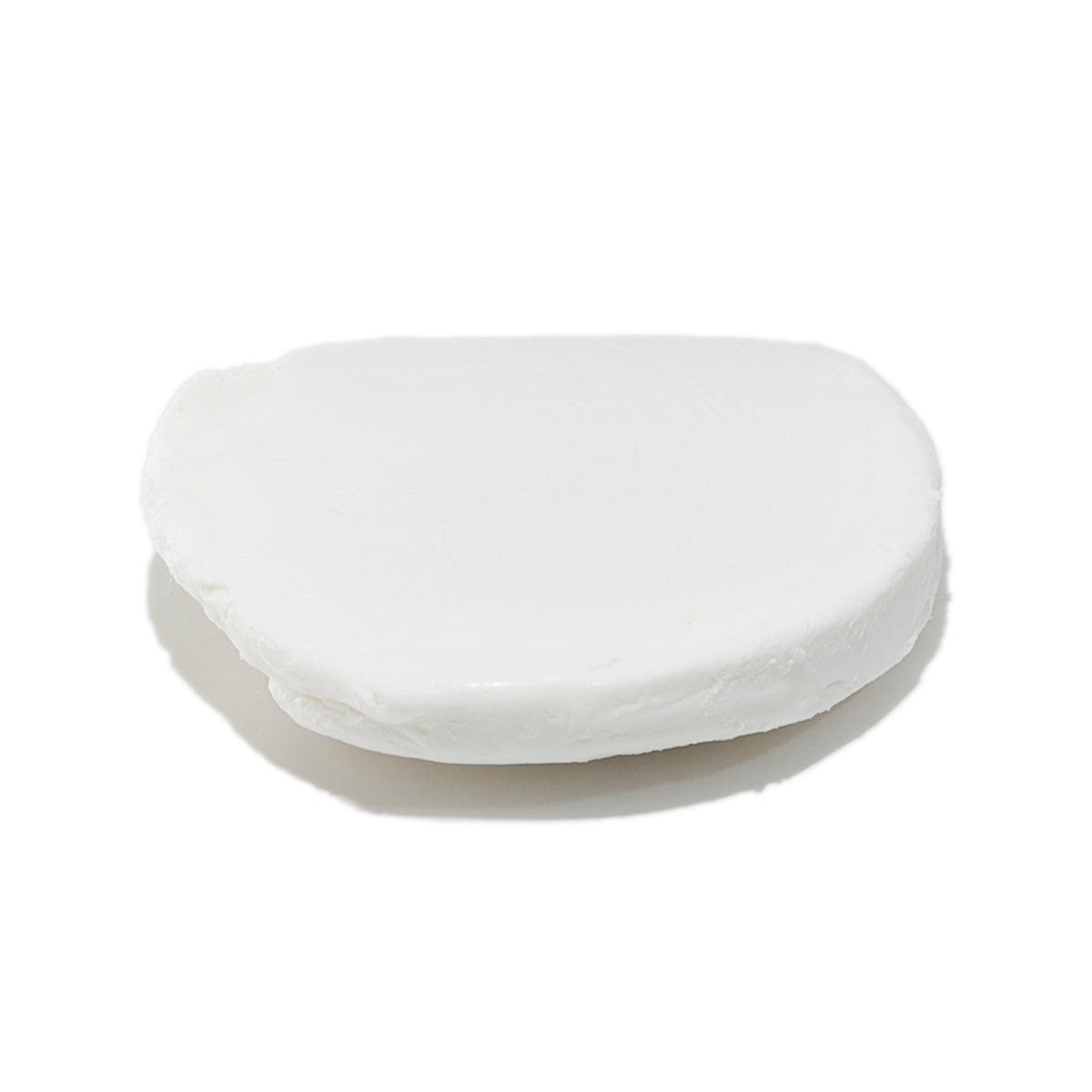 Soft white goat cheese log, smooth pale white oval