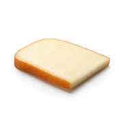 Basque sheep's milk cheese wedge with creamy pale interior and thin orange rind