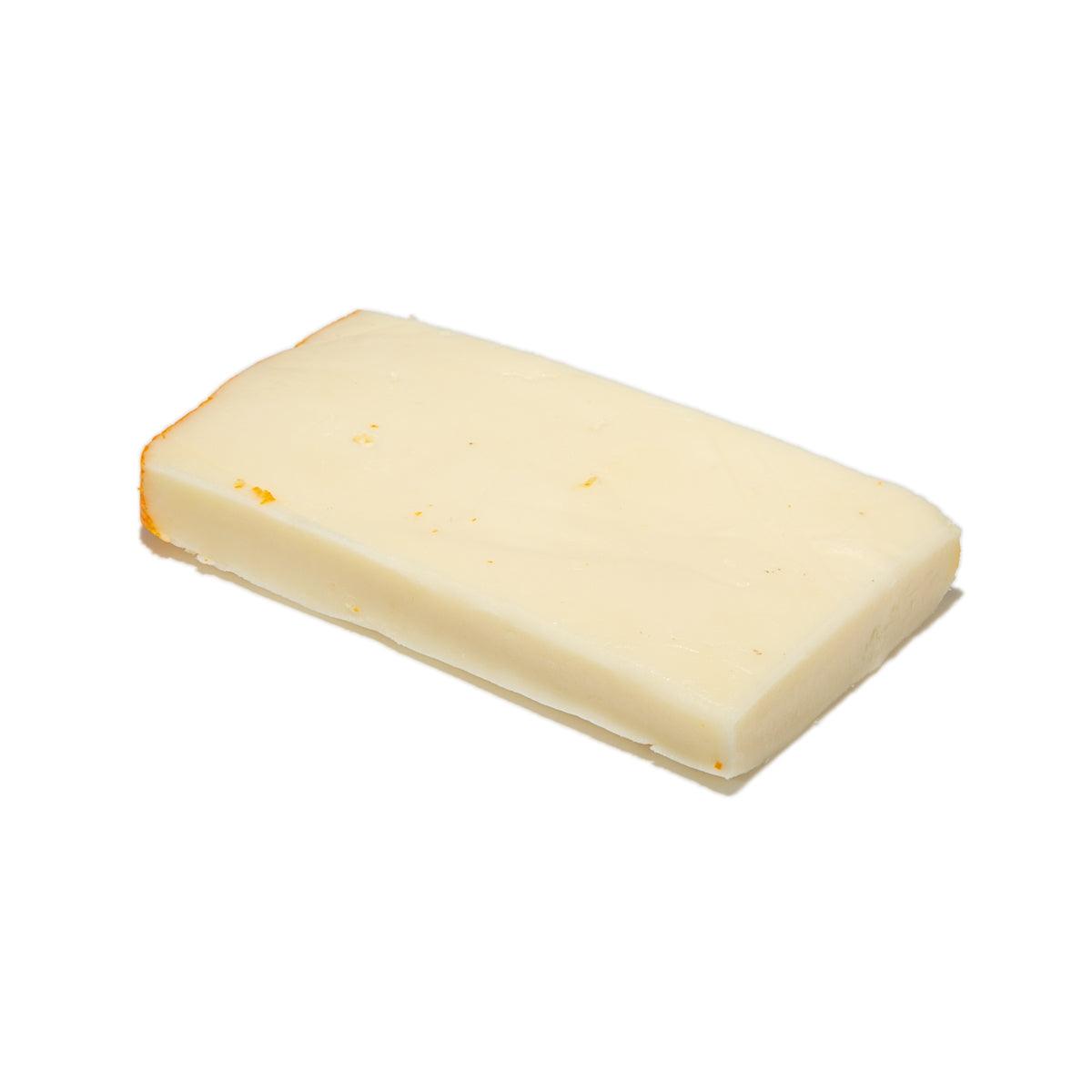 Port Salut cheese wedge, pale yellow, rectangular cut with light rind