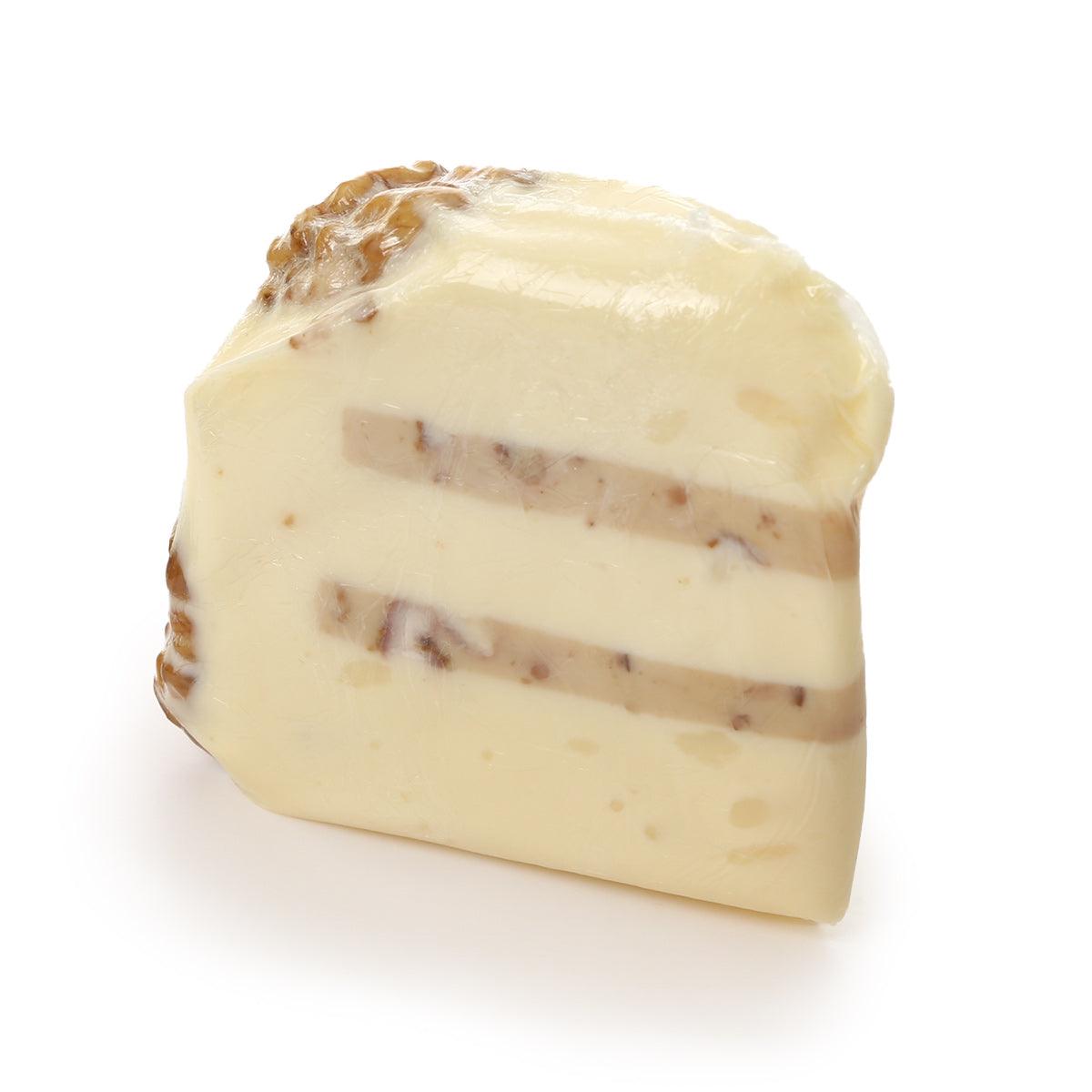 Cheese wedge with walnut pieces and pale yellow creamy texture