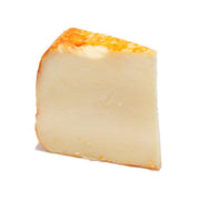 Wedge of smoke-flavored cheddar cheese with pale yellow interior and orange rind