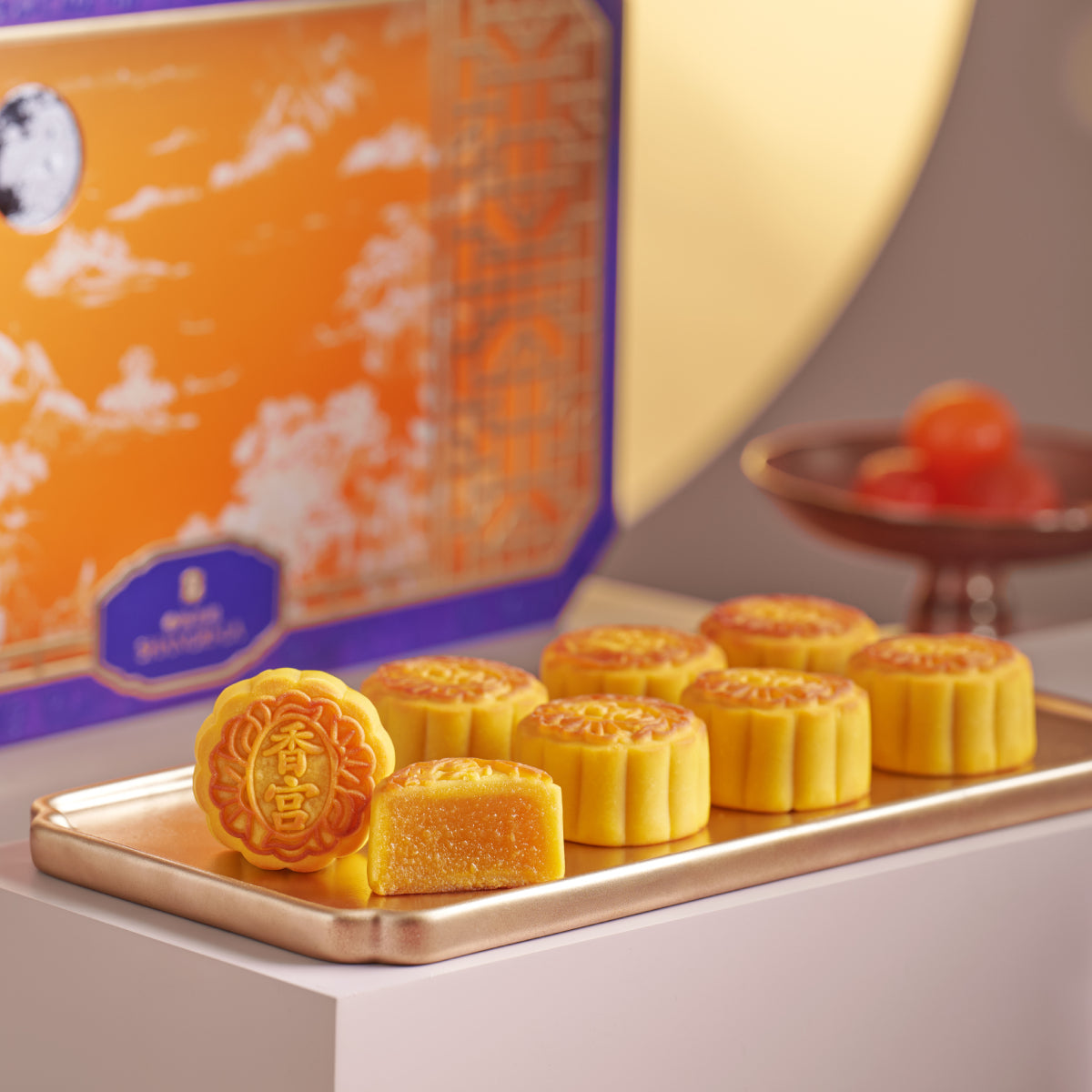 Mini egg custard mooncakes on a wooden tray, golden pastries with embossed pattern