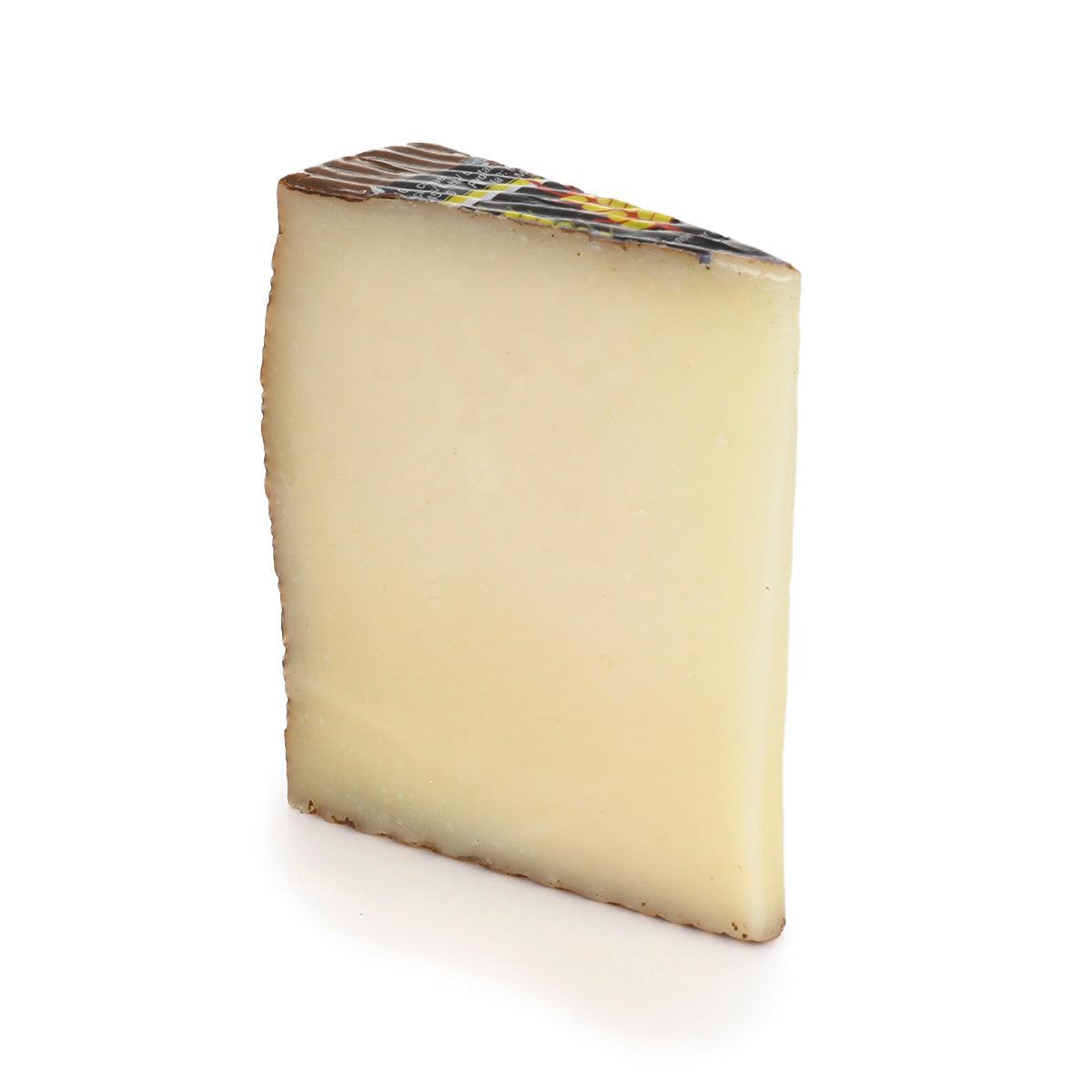 EL TRIGAL curado Manchego cheese wedge, pale yellow with light brown rind