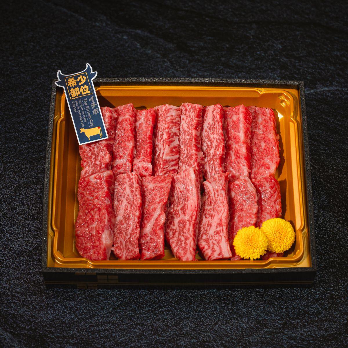 Chilled A5 wagyu beef strips in golden tray, marbled red slices with small tag