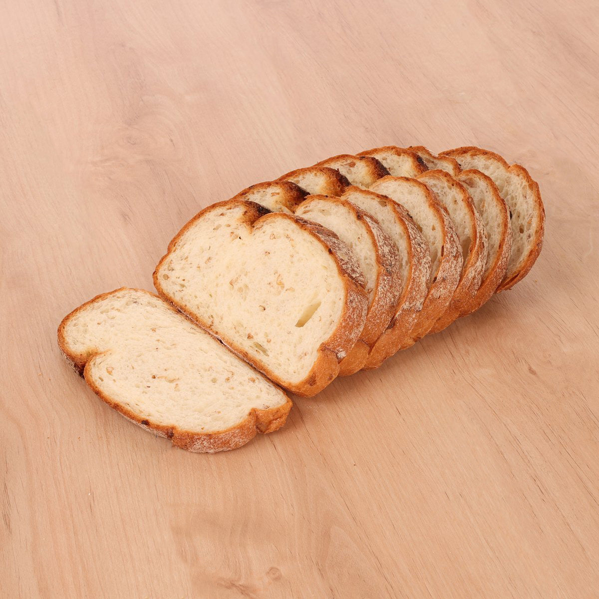 Sliced cereal bread loaf with golden crust, stacked slices and one side piece