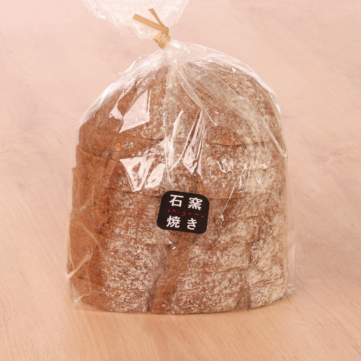 Rye grain bread loaf in clear bag, dark crust, round top with label
