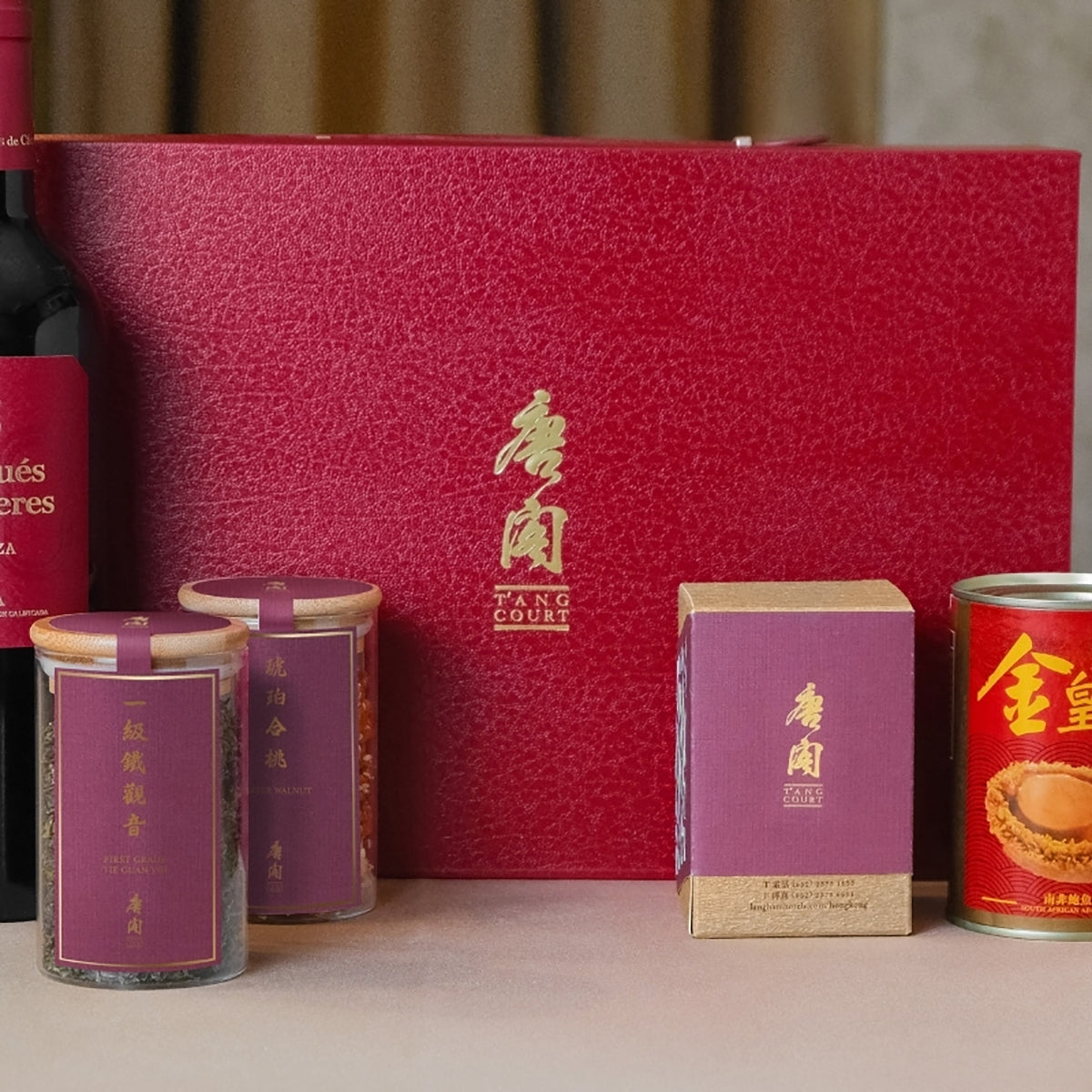 Red deluxe hamper box with gold T'ang Court emblem and small gift tins in front