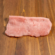 Chilled veal escalope, raw pink slice with visible fat marbling