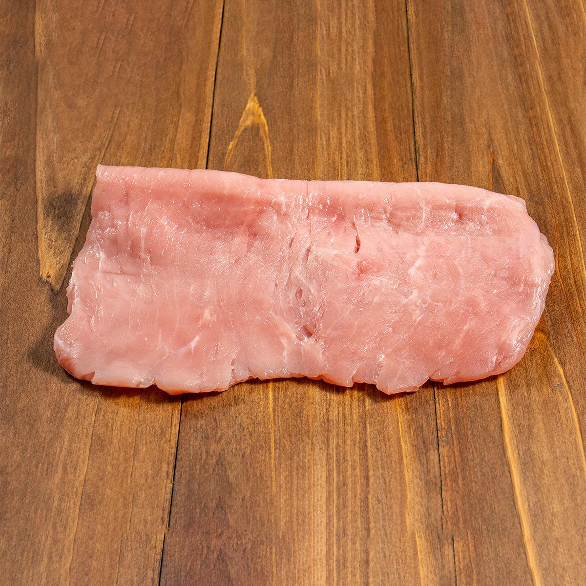 Chilled veal escalope, raw pink slice with visible fat marbling
