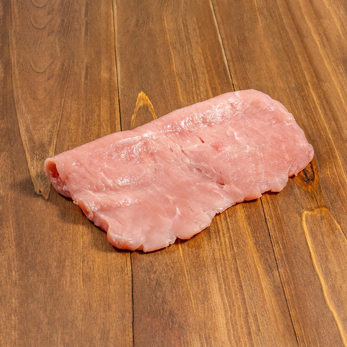 Chilled veal escalope, raw pink slice on edge, thin layered cut