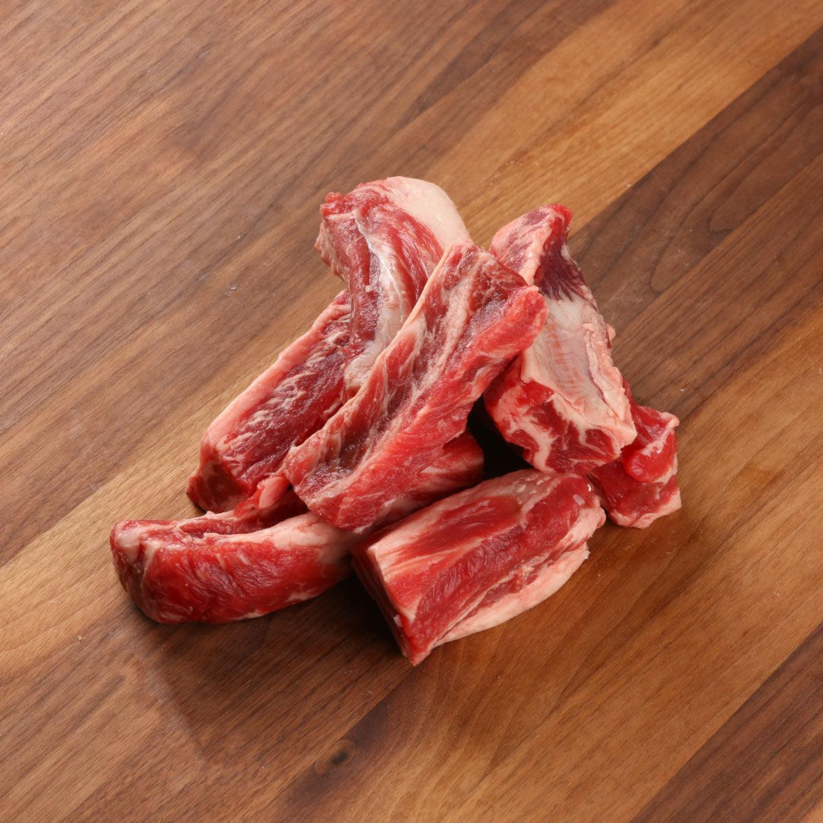Chilled organic beef rib finger cuts, raw red meat with visible bone and fat