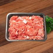 Boneless beef short rib slices, red and pink in metal tray.