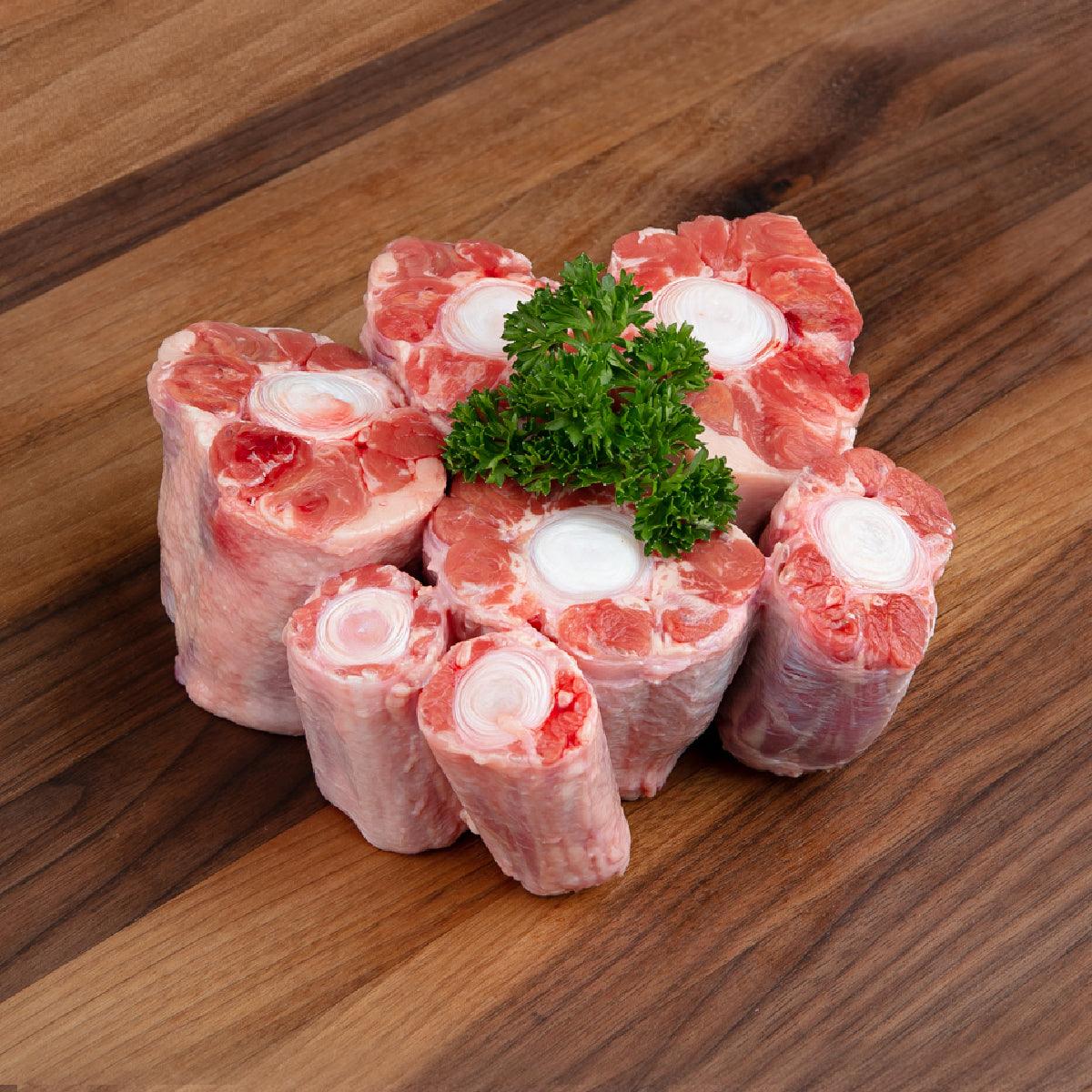 Chilled Angus oxtail pieces, bone-in cuts with parsley garnish