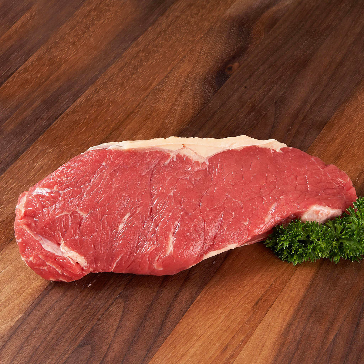 Raw organic beef striploin, red muscle with visible marbling and fat cap