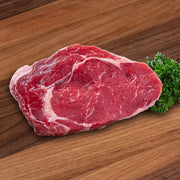 Organic rib eye steak, raw red beef with visible marbling and fat cap