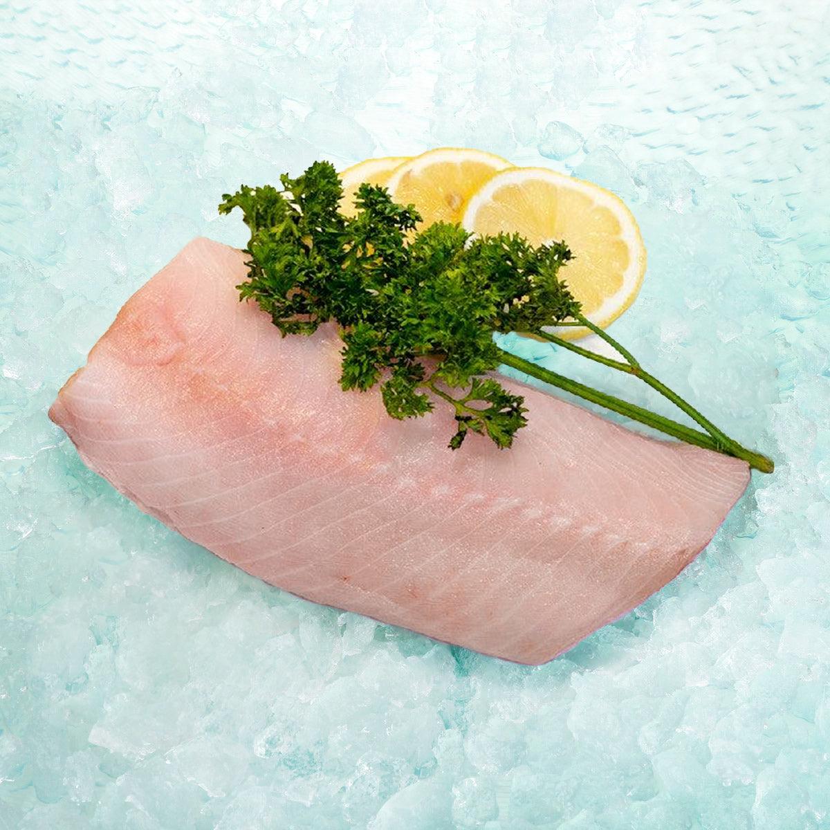Black cod slice, raw fillet with parsley and lemon garnish