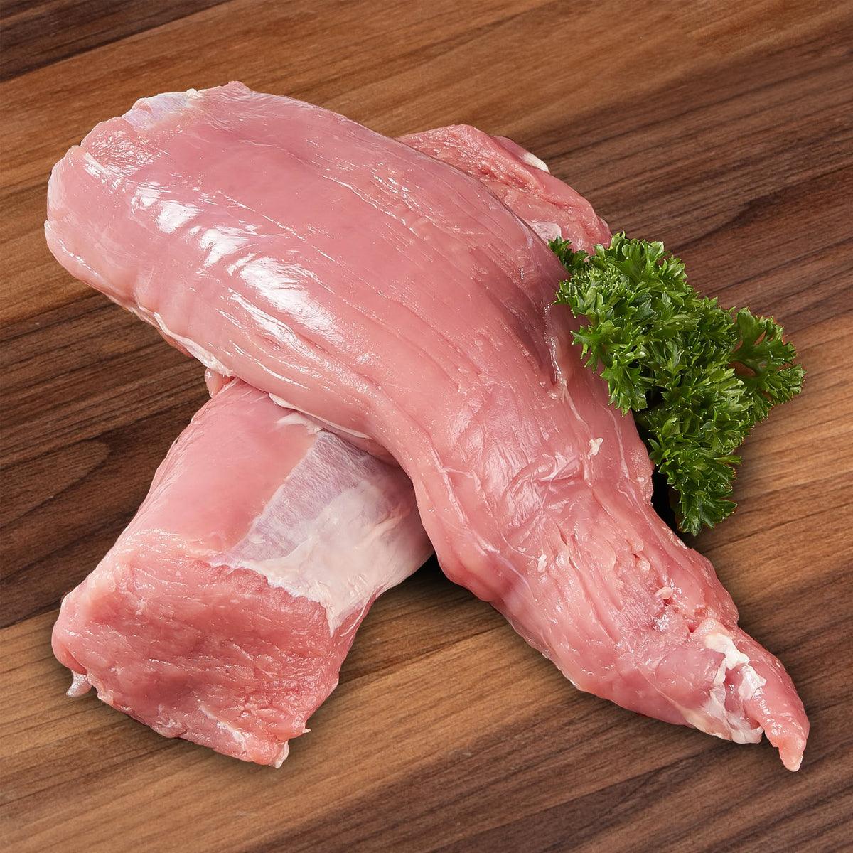 FRILAND Danish chilled organic pork tenderloin, raw pink meat with parsley garnish.