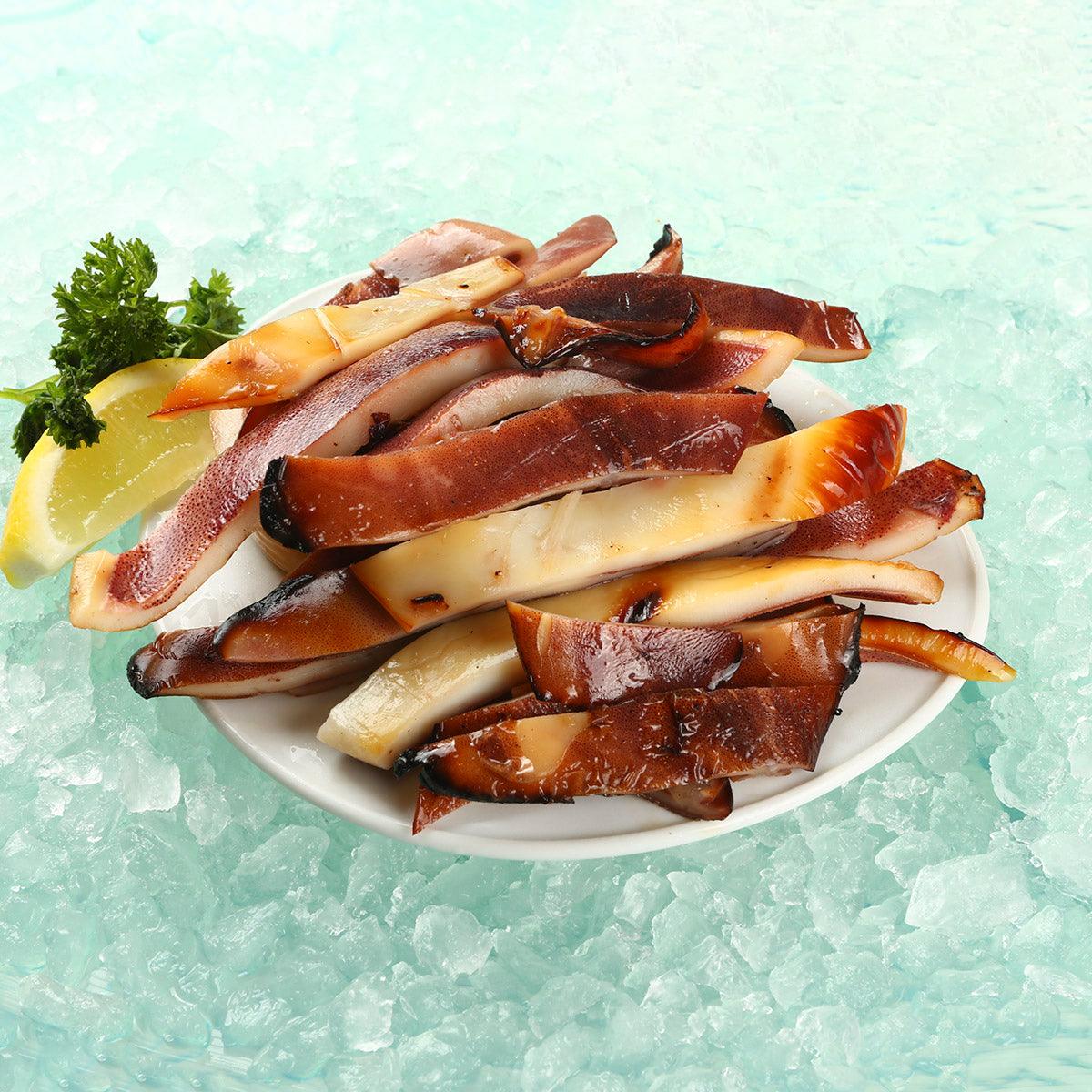 Grilled squid slices in a dish, glazed brown and off-white strips