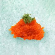 Flying fish roe mound with green garnish, bright orange roe granules