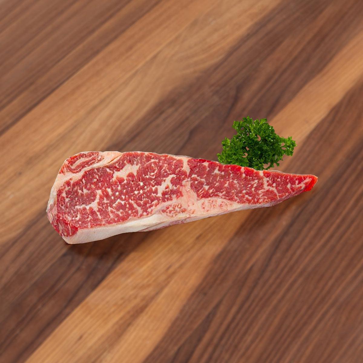Raw dry-aged Angus striploin steak, marbled with visible fat cap