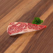 Raw dry-aged Angus striploin steak, marbled with visible fat cap