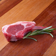 Raw lamb rib chop with rosemary sprigs on it