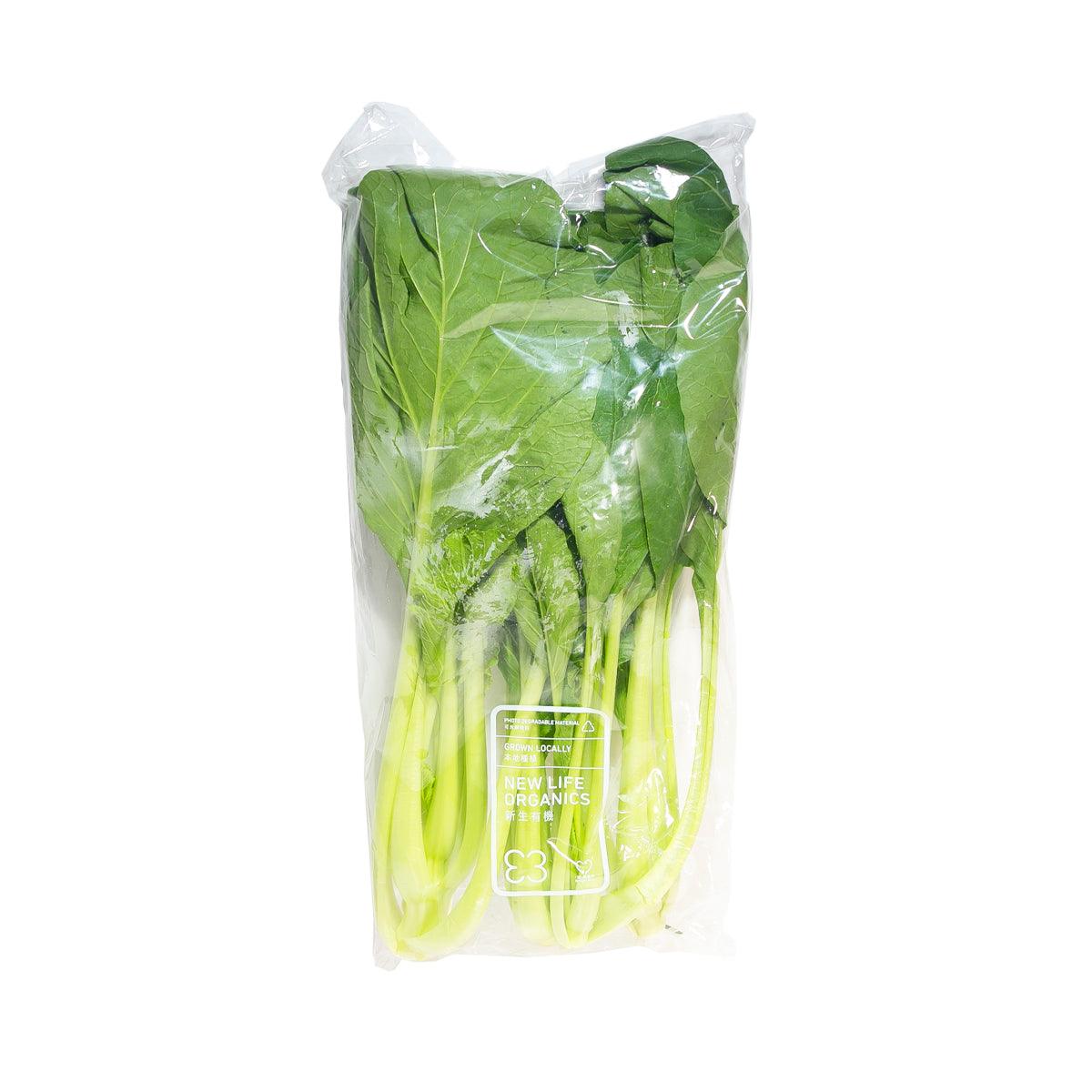 Organic yu choy in clear plastic bag with green leafy vegetables and stems