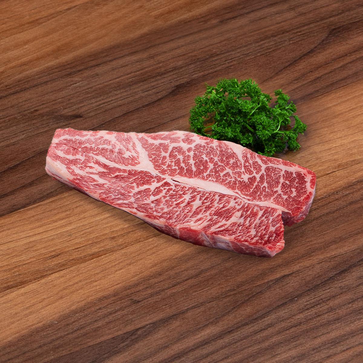 Boneless beef short rib steak, raw with visible marbling, red and white.