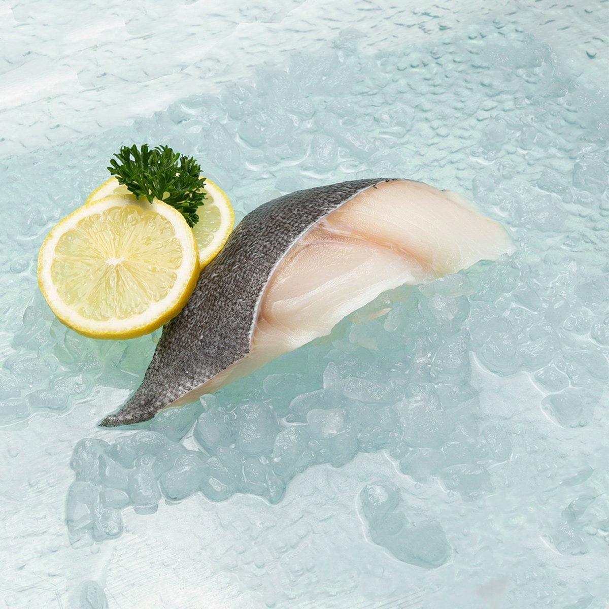 Frozen skin-on black cod fillet, pale pink-white flesh