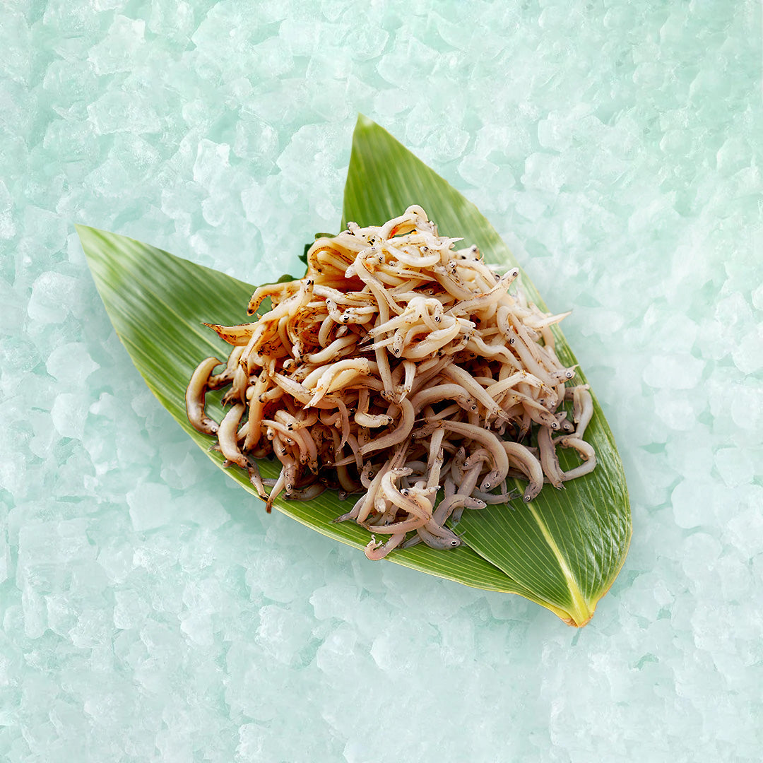 Seasoned whitebait in banana leaf, small white fish with glossy brown seasoning