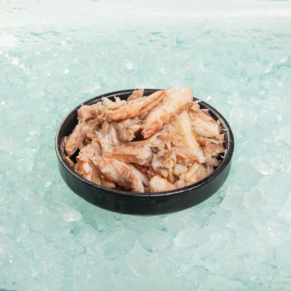 BYRD cooked crab claw meat in black bowl, shredded crab pieces