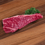 Marbled raw beef striploin steak, deep red with thin white fat streaks